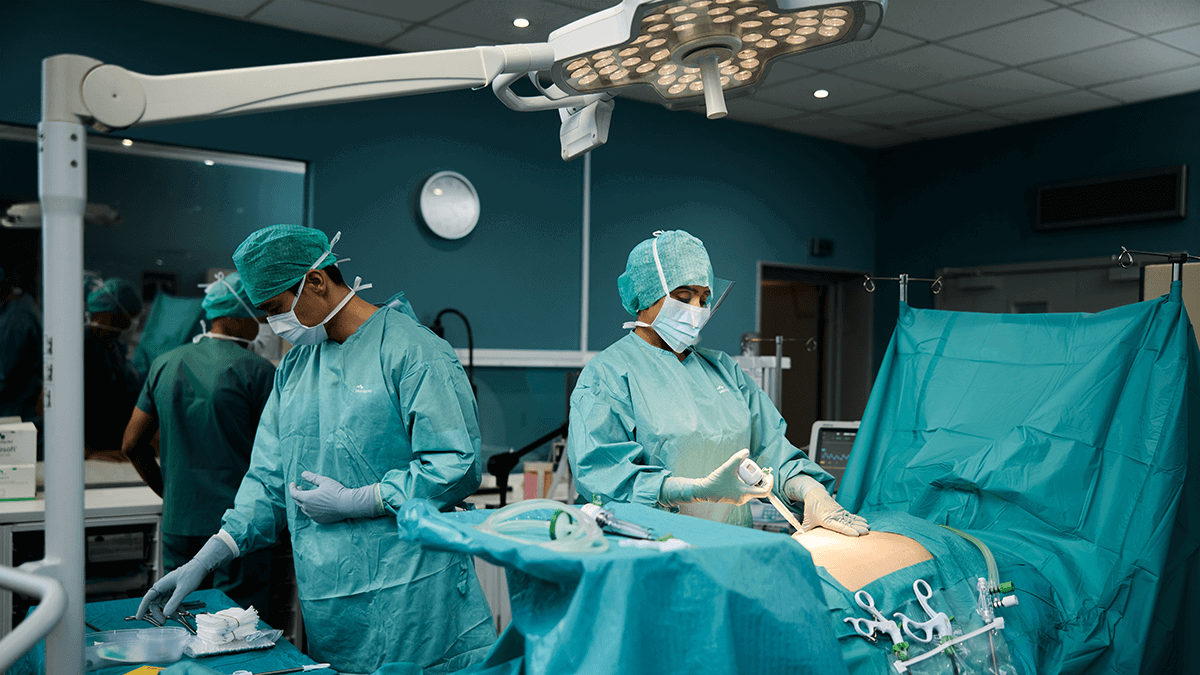 A surgeon and a nurse operating on a patient covered with Mölnlycke BARRIER surgical drapes.
